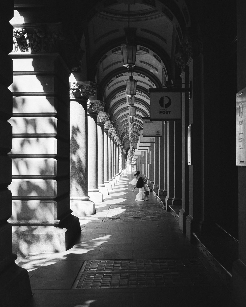 A colonnade with raking light across its arches
