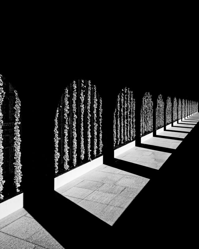 Deep shadows cast by a run of stone arches